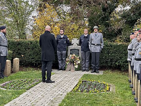 Volkstrauertag in Eggenstein-Leopoldshafen: Wir gedenken der Opfer von Krieg, Gewalt und Terror Zwei Mitglieder des DRK Ortsvereins Eggenstein-Leopoldshafen stehen jeweils links und rechts neben einem Kriegerdenkmal.